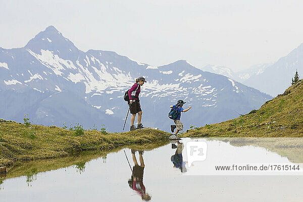 A mother and her six year old son hiking high in the Adamants Range.; Rocky Mountains  British Columbia  Canada.