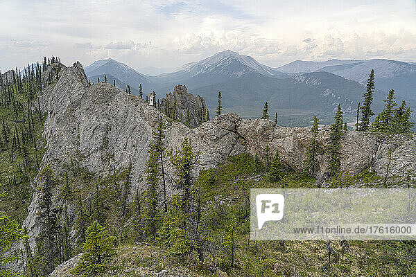Woman in a white dress standing in the beautiful Yukon landscapes; Yukon  Canada