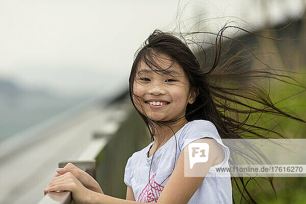 Außenporträt eines Mädchens mit vom Wind verwehtem Haar; Hongkong  China