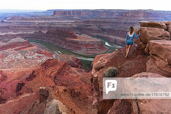 Eine Frau tritt an den Rand des Aussichtspunkts Horseshoe Bend.