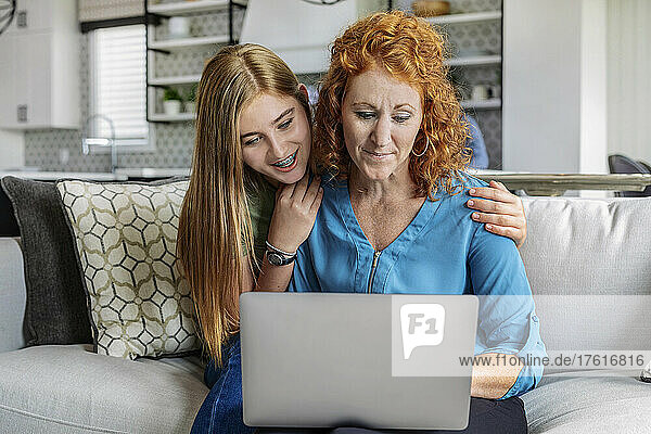 Mutter und Tochter schauen gemeinsam auf einen Laptop-Computer; Edmonton  Alberta  Kanada