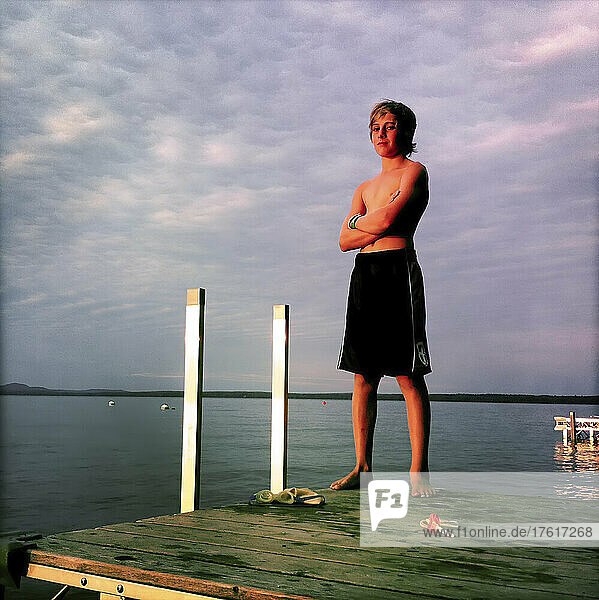 An eleven year old boy on summer vacation poses on a dock at Sebago Lake  Maine.; Sebago Lake  Maine  United States.