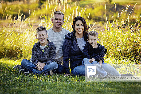 Portrait of a young family in a park in autumn with two boys; St. Albert  Alberta  Canada
