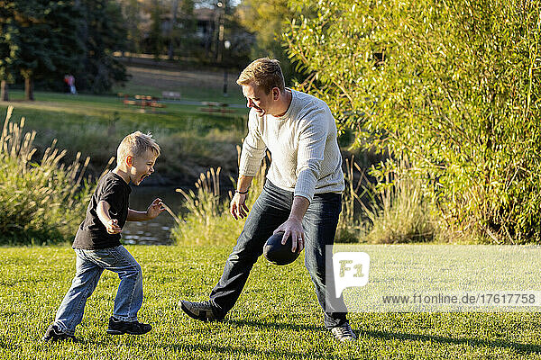Vater spielt Fußball mit seinem kleinen Sohn in einem Park im Herbst; St. Albert  Alberta  Kanada