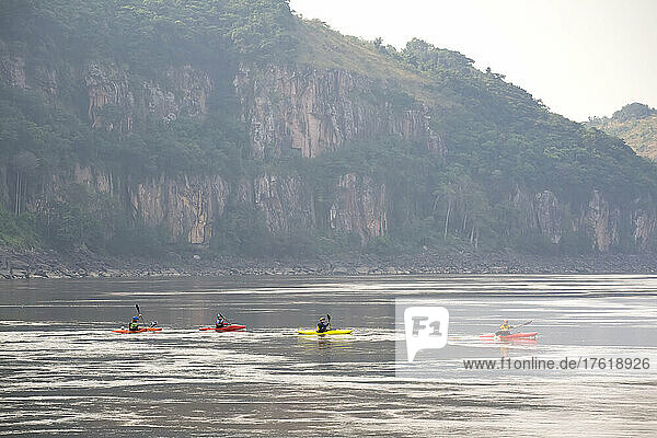Kayakers paddle across flat water in The String of Pearls canyon.; Lower Congo River  Democratic Republic of the Congo.