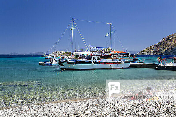 Sunbathers enjoying Sesklia Beach on Symi Island in Greece; Symi  Dodecanese  Greece