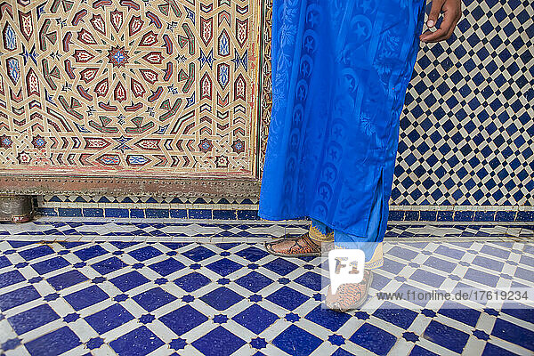 Ein Mann aus einem Berberdorf geht entlang der verzierten Kacheln im Mausoleum von Moulay Ali al-Sharif in Erfoud; Erfoud  Marokko