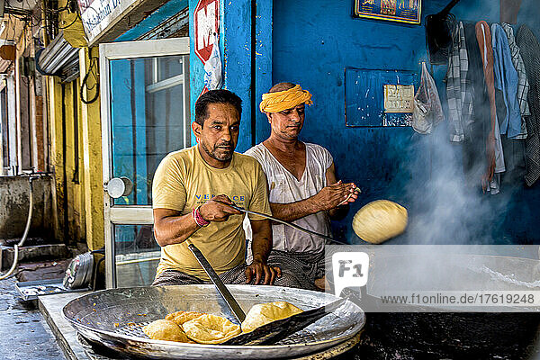 Men making traditional Indian food at a street stall in India  deep fried fluffed bread; Amritsar  Punjab  India