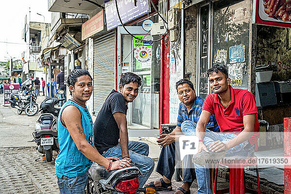 Young men sitting together on a street in a city in India; Amritsar  Punjab  India