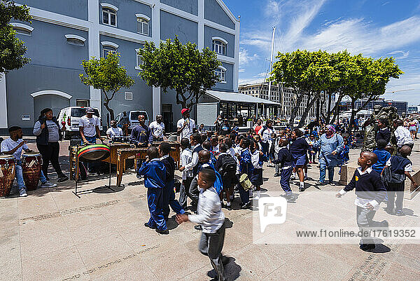 Schulkinder in Uniform halten an  um einer Perkussionsmusikgruppe am Hafen von Kapstadt zuzuhören; Kapstadt  Südafrika
