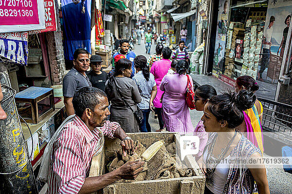 Vendor bartering with shopper  and pedestrians on a street in India; Amritsar  Punjab  India
