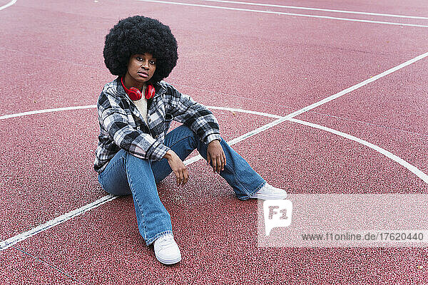 Afro woman sitting on sports court