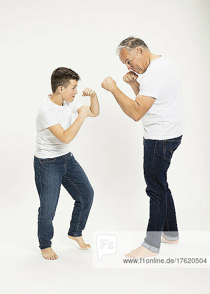 Father with son playing boxing at studio