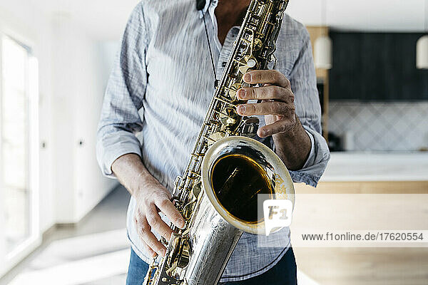 Musician practicing saxophone at home