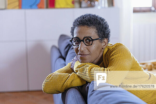 Woman with eyeglasses leaning on sofa at home