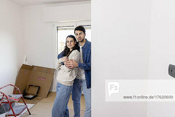 Young couple embracing at home renovation work