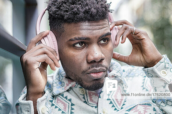 Young man listening music through wireless headphones