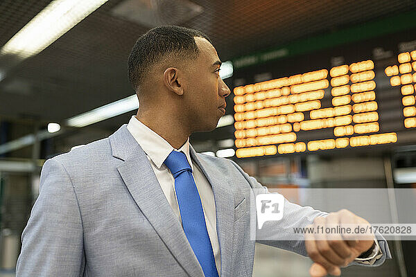 Businessman checking time waiting at train station