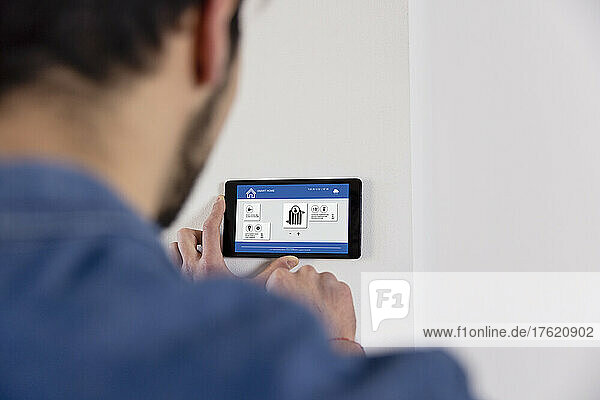Mann nutzt IOT-Heim-App über Tablet-PC im neuen Zuhause