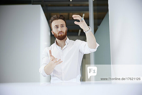 Businessman analyzing invisible object at office