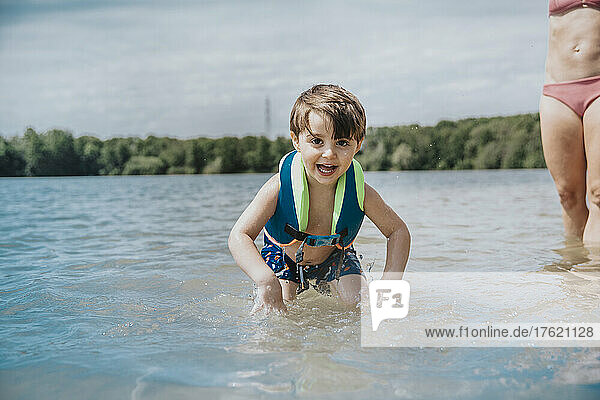 Happy boy playing in lake on weekend