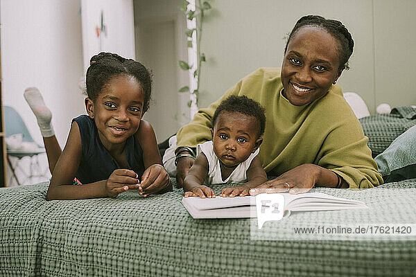 Smiling mother with son and daughter in bedroom