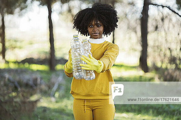 Environmentalist showing plastic bottle at park