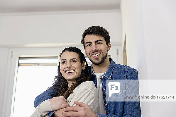 Smiling couple embracing at home renovation work