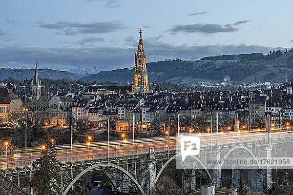 Switzerland  Canton of Bern  Bern  Kornhausbrucke bridge at dusk with bell tower of Cathedral of Bern in background