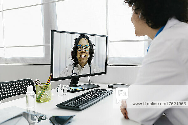 Doctor on video call with colleague through desktop PC at clinic