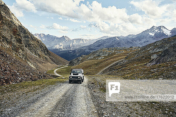 Off-road vehicle on gravel road by mountains  Schnalstal  South Tyrol  Italy