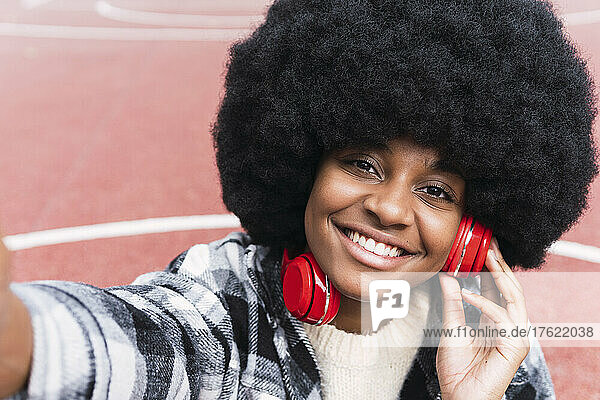 Afro woman listening music on headphones