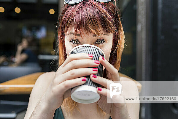 Woman drinking coffee in disposable cup