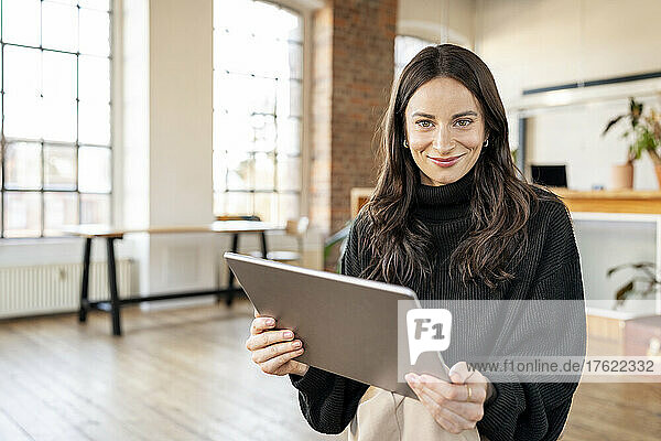 Beautiful freelancer with tablet PC sitting at home