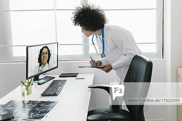 Doctor on video call with colleague through desktop PC at medical clinic