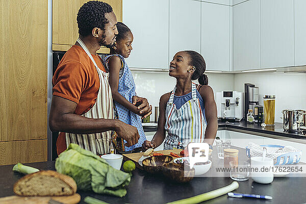 Father talking with daughters in kitchen