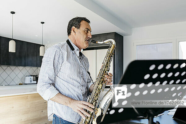 Musician blowing saxophone practicing at home