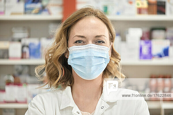 Pharmacist wearing protective face mask in pharmacy store