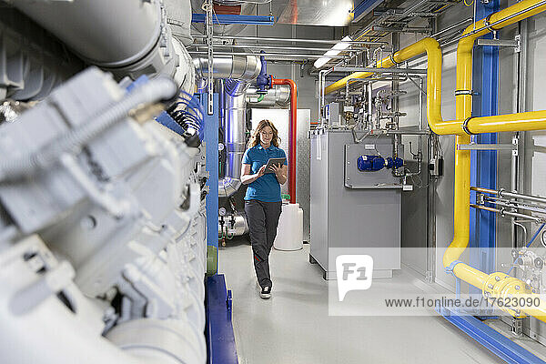 Technician using tablet PC walking in factory