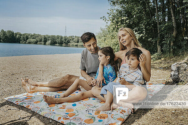 Family spending leisure time at lakeshore on weekend