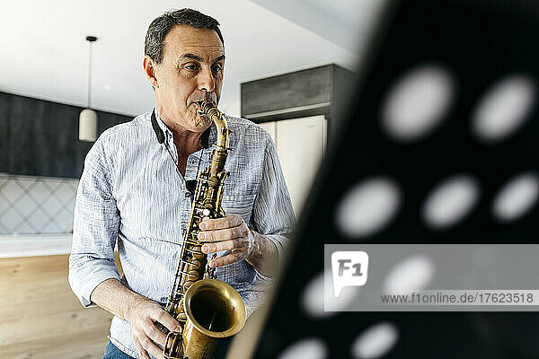 Saxophonist practicing saxophone at home