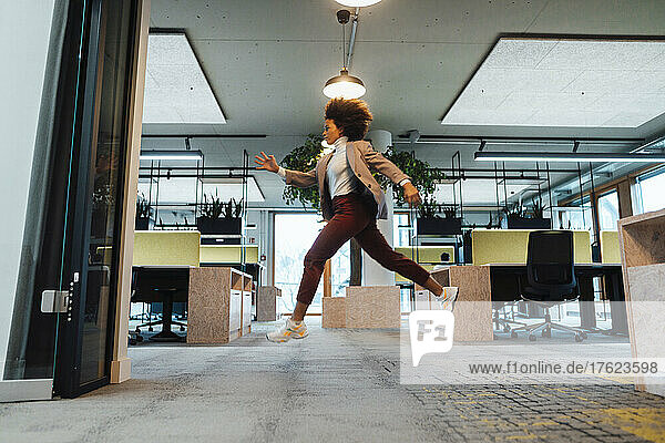 Businesswoman jumping in office