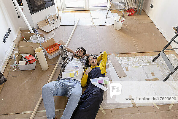 Young couple day dreaming with color swatches at home renovation works
