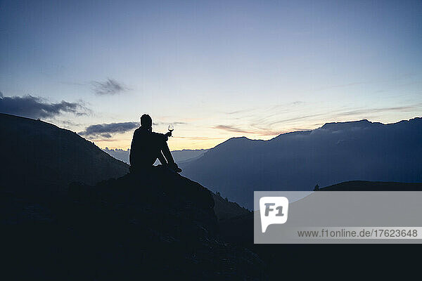 Silhouette of woman admiring mountains at sunset  Colle dell'Assietta  Turin  Italy