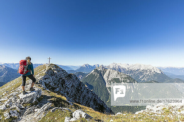 Female hiker admiring surrounding landscape from mountaintop