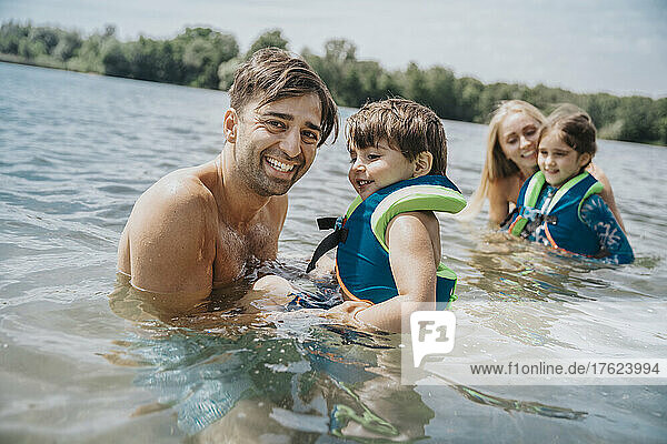 Family swimming in lake on weekend
