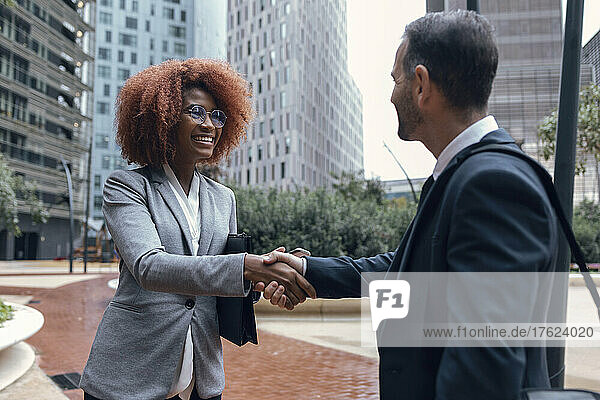Two business colleagues shaking hands outdoors