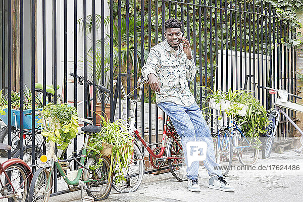 Man talking on mobile phone sitting on bicycle