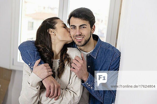 Woman kissing boyfriend at new home