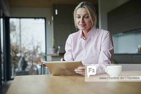 Woman using tablet PC sitting at table